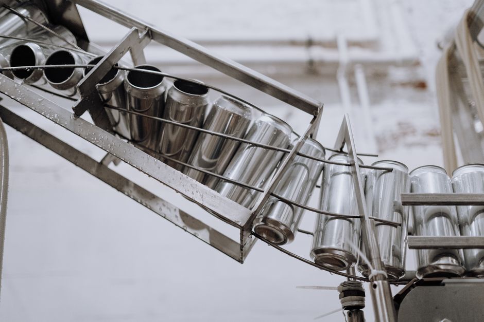 Conveyor belt with empty aluminum cans in a factory setting, showcasing production equipment. (Photo: cottonbro studio / Pexels)
