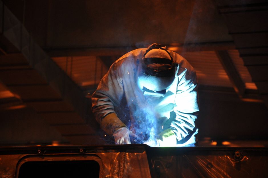 A welder at work in a Turkish factory with bright sparks illuminating the scene. (Photo: Uğur Bozdoğan / Pexels)