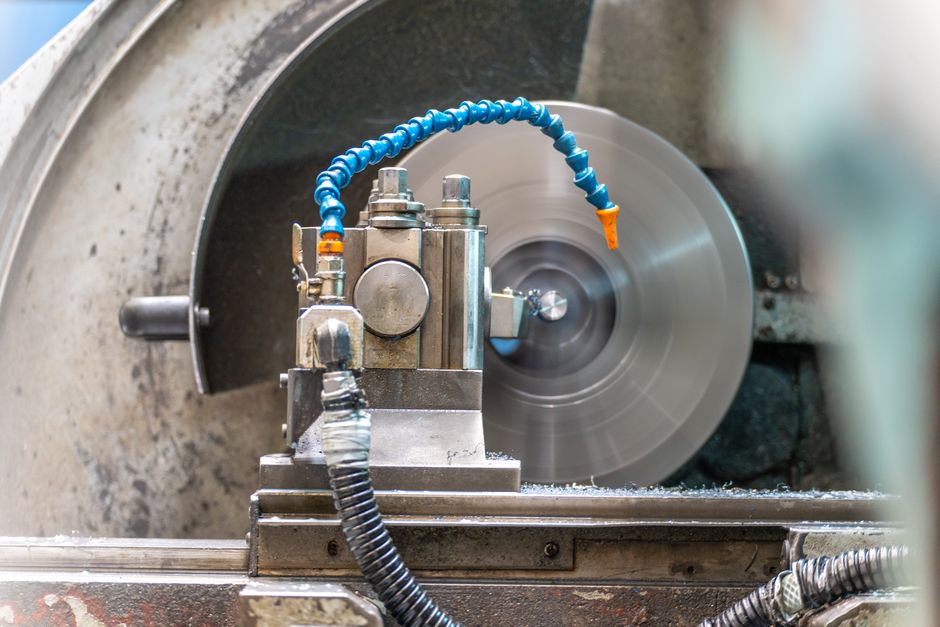 Close-up of a spinning lathe machine in an industrial workshop setting. (Photo: Connor Lucock / Pexels)