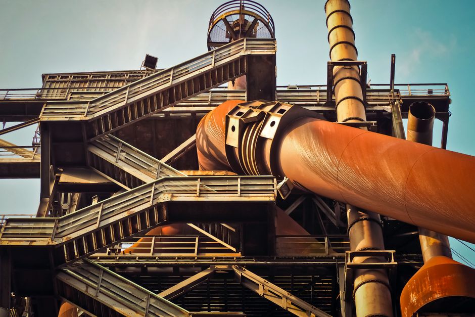 Close-up view of a rusty industrial structure with large pipes and steel framework, showcasing industrial decay. (Photo: Pixabay / Pexels)