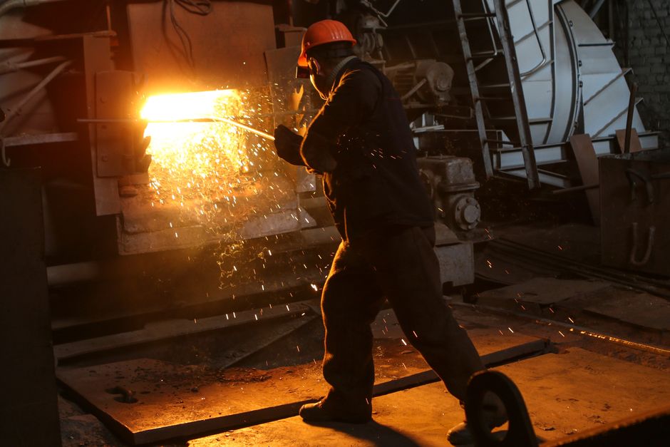 A worker in protective gear welds metal in an industrial plant with sparks flying. (Photo: Kateryna Babaieva / Pexels)