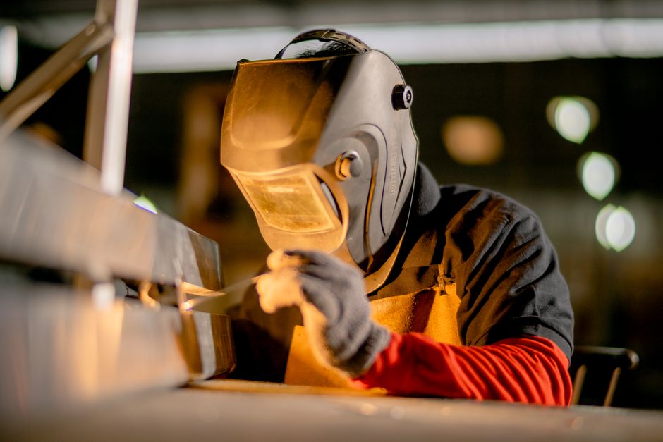 A welder focused on metalwork in an industrial factory, showcasing skill and precision. (Photo: Mandiri Abadi / Pexels)