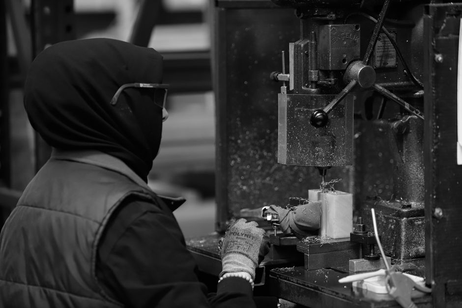 Black and white image of a worker operating machinery in a factory in Sakarya, Türkiye. (Photo: Gökhan Sirkeci / Pexels)