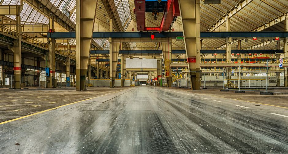 Wide view of an empty industrial warehouse with visible cranes and metal structures. (Photo: Pixabay / Pexels)