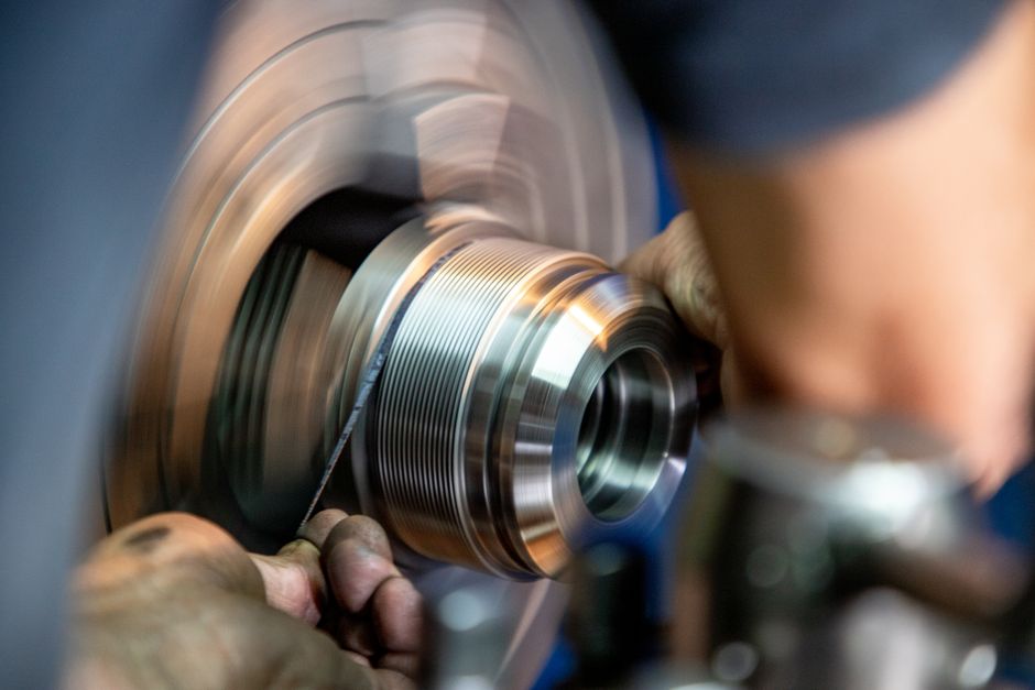 Close-up view of a worker grinding metal, showcasing precision and craftsmanship in industrial setting. (Photo: Alex Domínguez / Pexels)