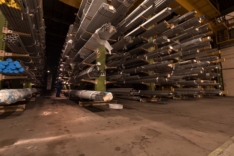 Indoor view of an industrial warehouse filled with steel pipes stored on shelves. (Photo: Zakhar Vozhdaienko / Pexels)