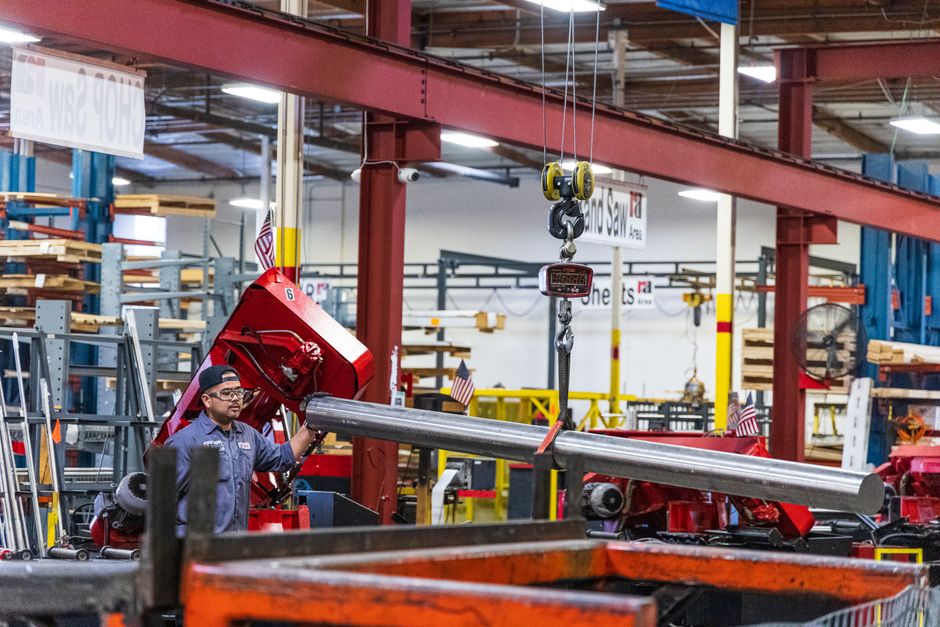 Worker operating heavy machinery in a factory, moving steel bars. Industrial scene indoors. (Photo: Rolled Alloys Specialty Metal Supplier / Pexels)