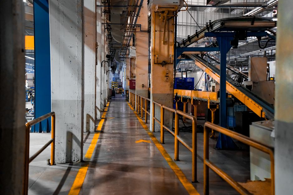 Inside view of an industrial factory featuring conveyor belts and empty walkways. (Photo: Yetkin Ağaç / Pexels)